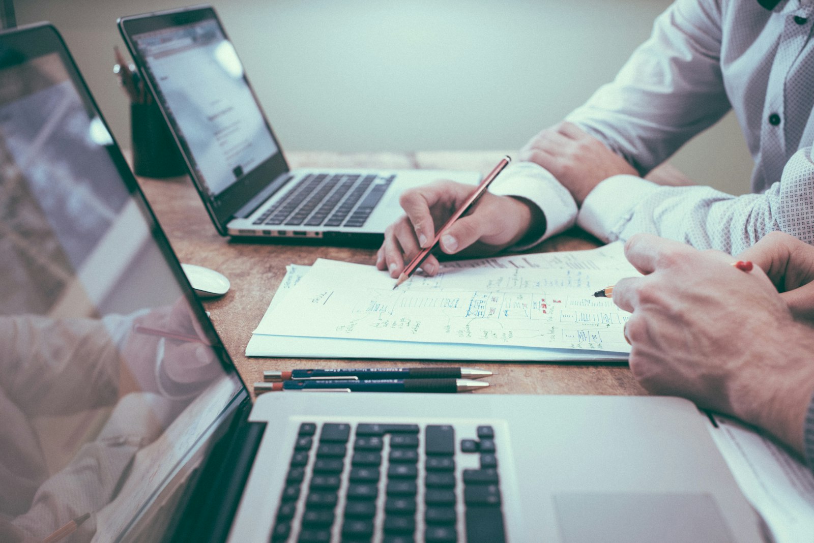 Consultants reviewing notes and documents at a work table